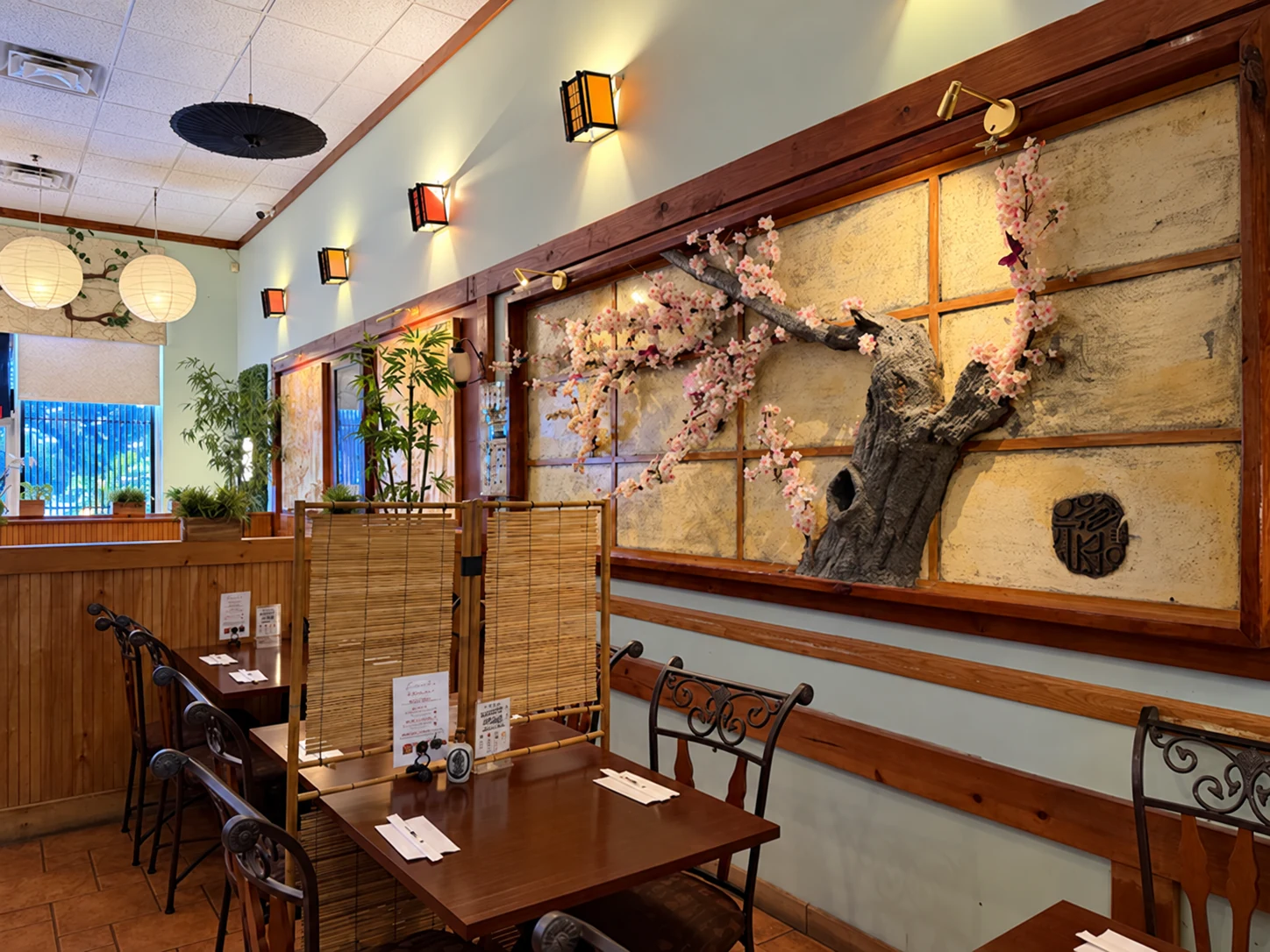 Wood booths beside Midori Sushi’s cherry-blossom wall